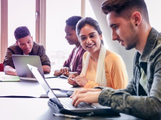 People around a table on laptops